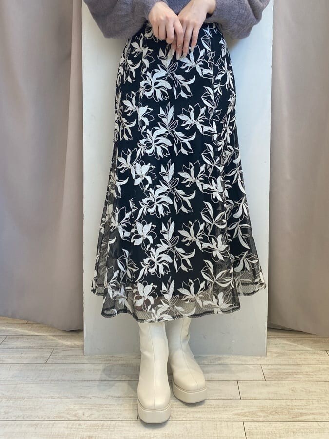 パープル系のニット/セーター、ブラック系のスカート、ブラック系のスカートを着用したレディースの秋コーディネートの7枚目の写真