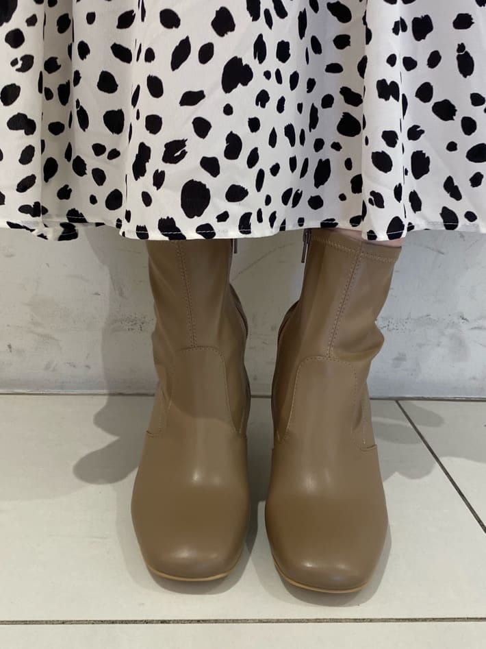 ベージュ系のブーツ、ブラウン系のハンドバッグ、ホワイト系のワンピースを着用したレディースの秋コーディネートの6枚目の写真