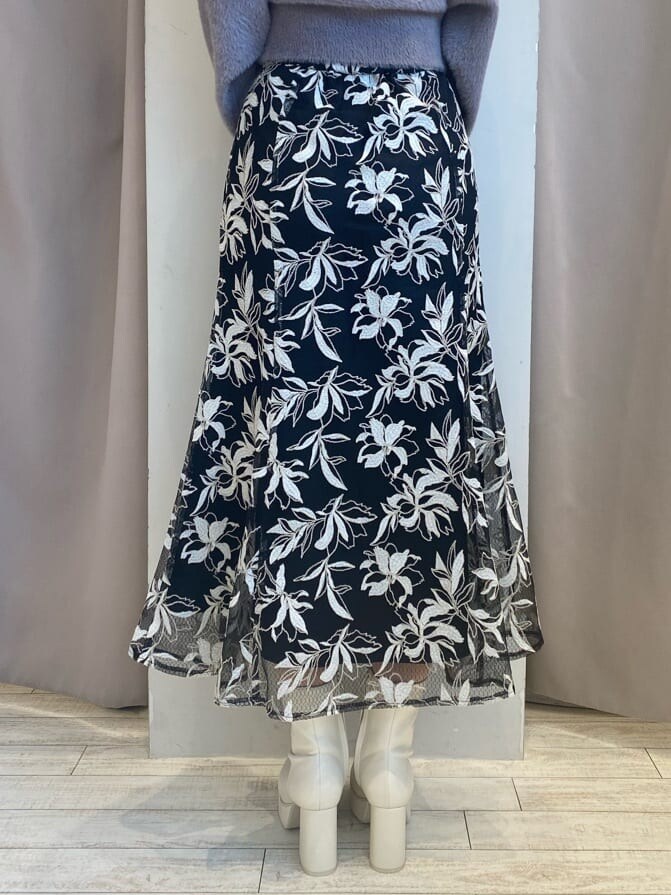 パープル系のニット/セーター、ブラック系のスカート、ブラック系のスカートを着用したレディースの秋コーディネートの8枚目の写真