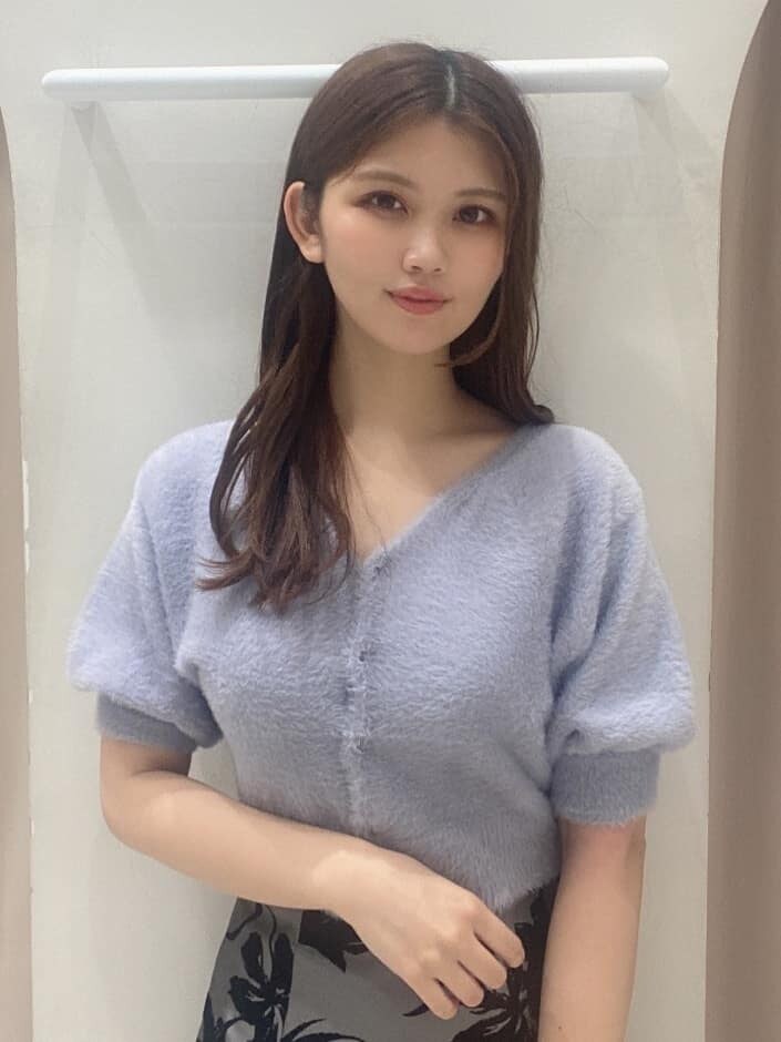 グレー系のスカート、ホワイト系のブーツ、ブラウン系のハンドバッグを着用したレディースの夏コーディネートの5枚目の写真