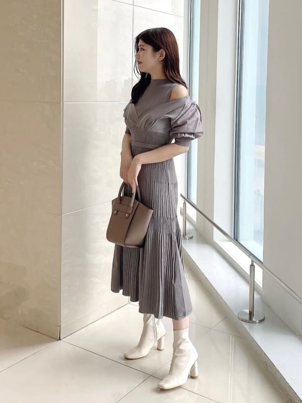 ベージュ系のワンピース、ホワイト系のブーツを着用したレディースの夏コーディネートの2枚目の写真