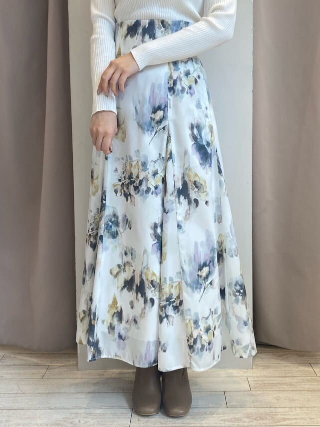 ホワイト系のスカート、ホワイト系のニット/セーター、ブラウン系のダウンジャケット/コートを着用したレディースの秋コーディネートの9枚目の写真