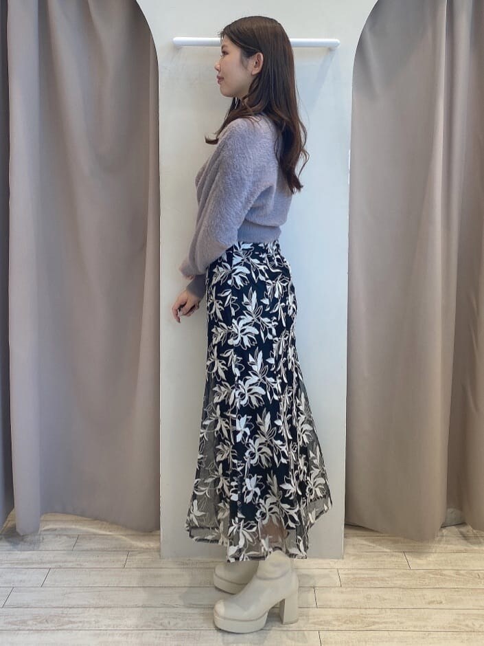 パープル系のニット/セーター、ブラック系のスカート、ブラック系のスカートを着用したレディースの秋コーディネートの2枚目の写真