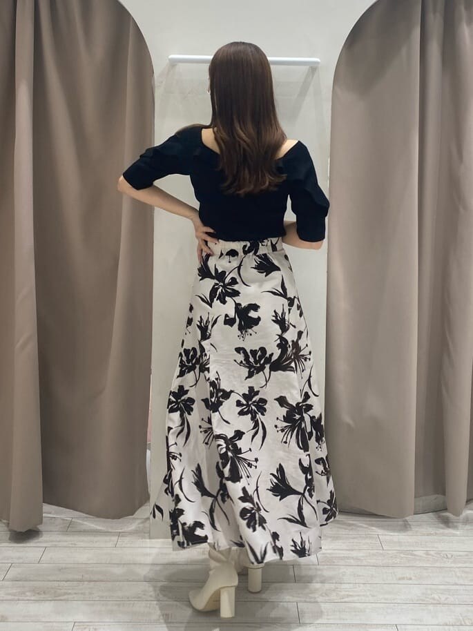 ホワイト系のスカート、ホワイト系のブーツ、ブラック系のニット/セーターを着用したレディースの夏コーディネートの2枚目の写真