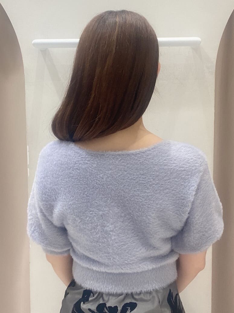 グレー系のスカート、ホワイト系のブーツ、ブラウン系のハンドバッグを着用したレディースの夏コーディネートの7枚目の写真