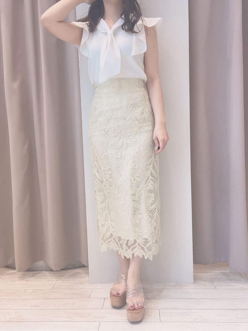 イエロー系のスカート、ホワイト系のニット/セーター、その他のサンダルを着用したレディースの春コーディネートの5枚目の写真