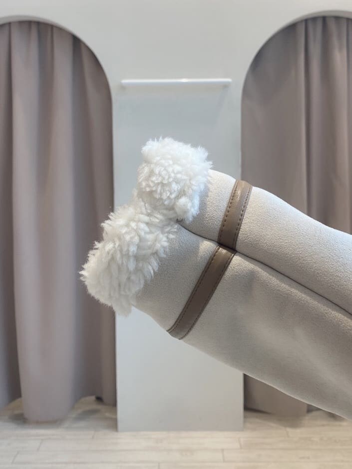 ブラウン系のブーツ、ベージュ系のムートンコート、ホワイト系のワンピースを着用したレディースの夏コーディネートの7枚目の写真