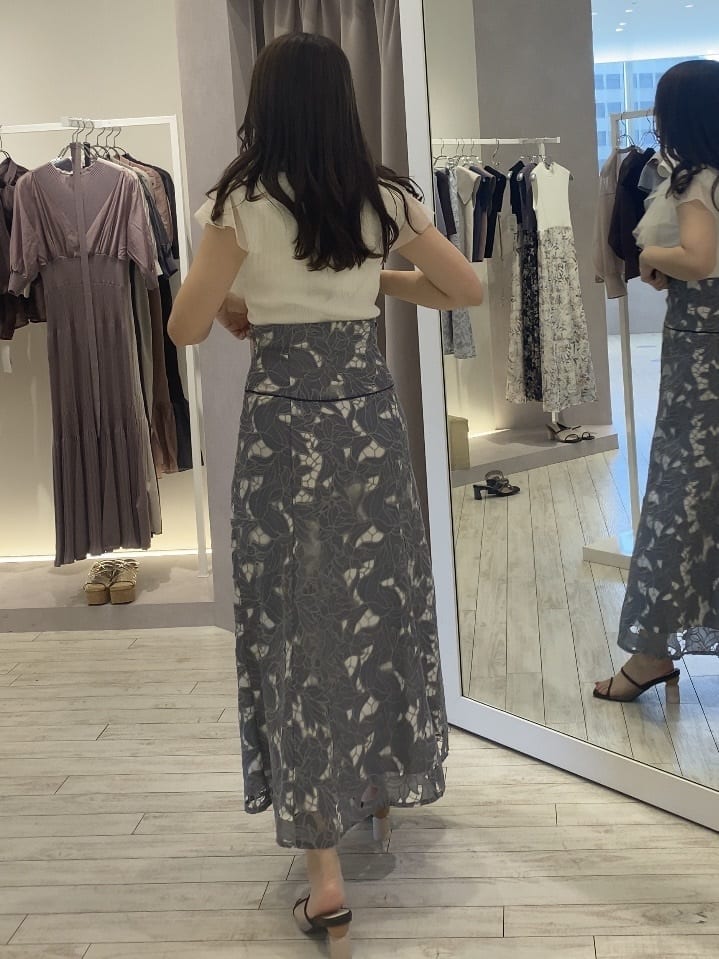 ベージュ系のトートバッグ、ホワイト系のカーディガン/ボレロ、ブルー系のスカートを着用したレディースの夏コーディネートの2枚目の写真