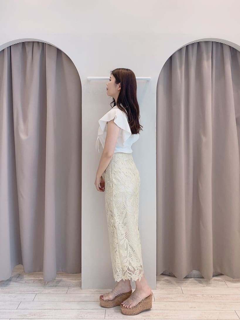 イエロー系のスカート、ホワイト系のニット/セーター、その他のサンダルを着用したレディースの春コーディネートの3枚目の写真