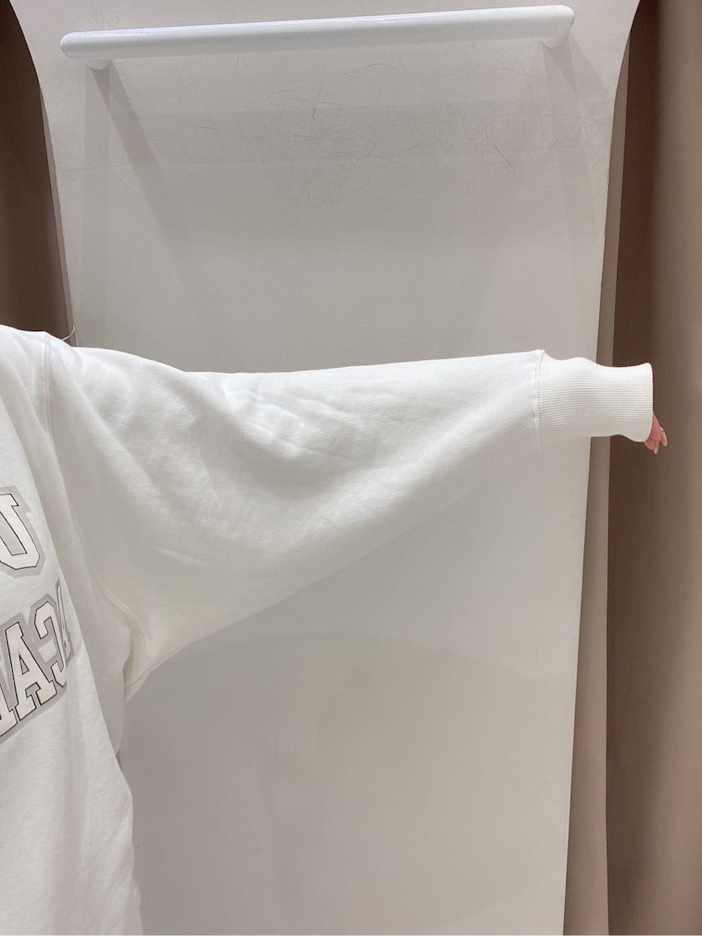 ホワイト系のスウェット、ブラック系のスカート、ブラック系のブーツを着用したレディースの冬コーディネートの4枚目の写真