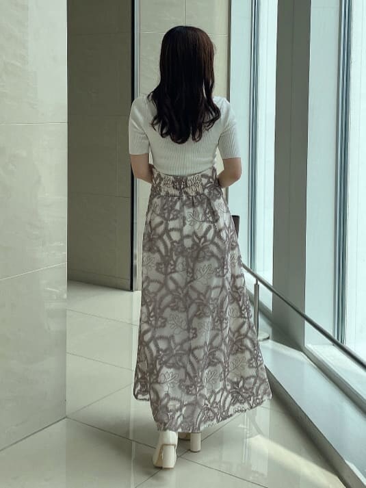 ホワイト系のスカート、ホワイト系のブーツ、ブラウン系のハンドバッグを着用したレディースの夏コーディネートの3枚目の写真