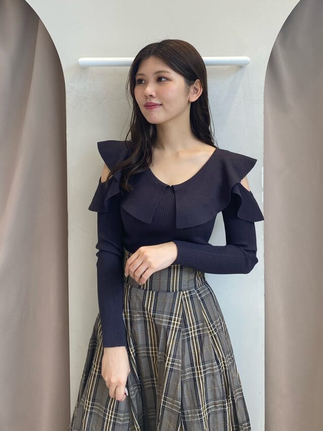 ベージュ系のスカート、グレー系のニット/セーター、ベージュ系のスカートを着用したレディースの秋コーディネートの4枚目の写真