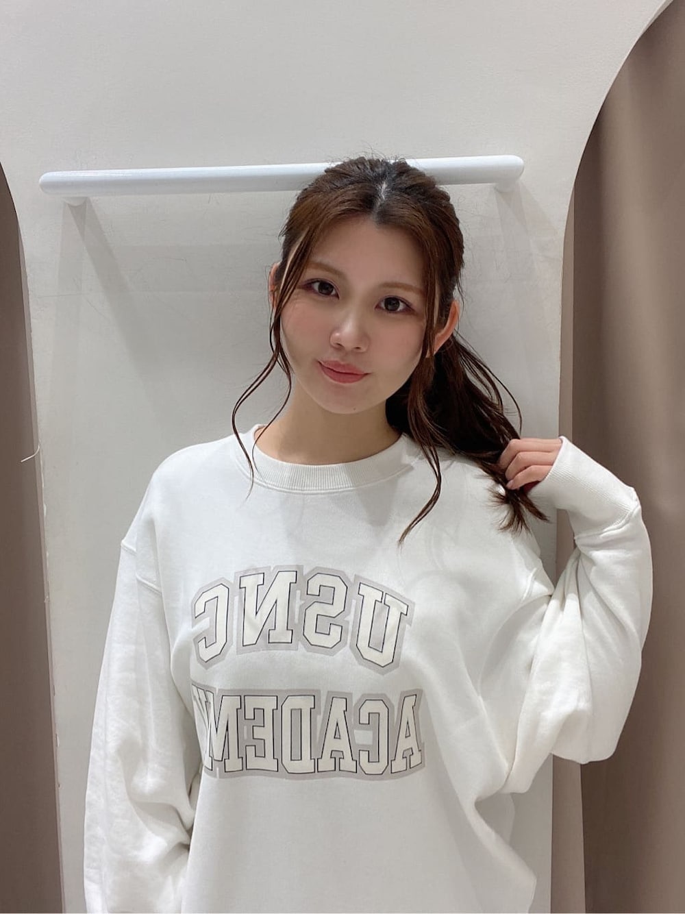 ホワイト系のスウェット、ブラック系のスカート、ブラック系のブーツを着用したレディースの冬コーディネートの3枚目の写真