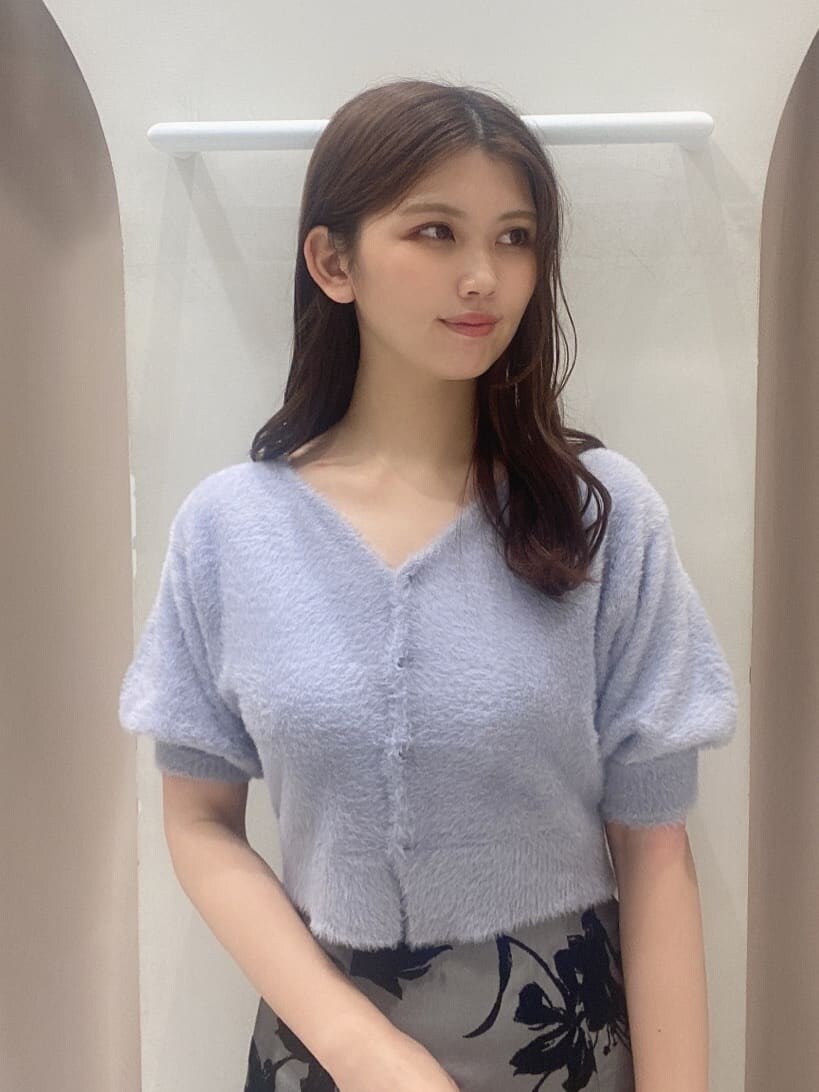 グレー系のスカート、ホワイト系のブーツ、ブラウン系のハンドバッグを着用したレディースの夏コーディネートの6枚目の写真