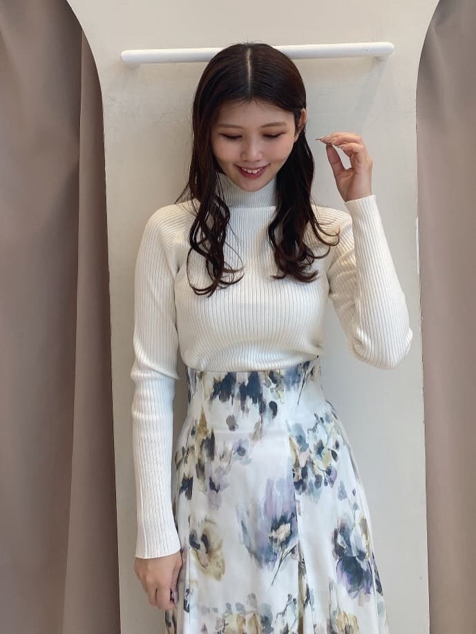 ホワイト系のスカート、ホワイト系のニット/セーター、ブラウン系のダウンジャケット/コートを着用したレディースの秋コーディネートの7枚目の写真