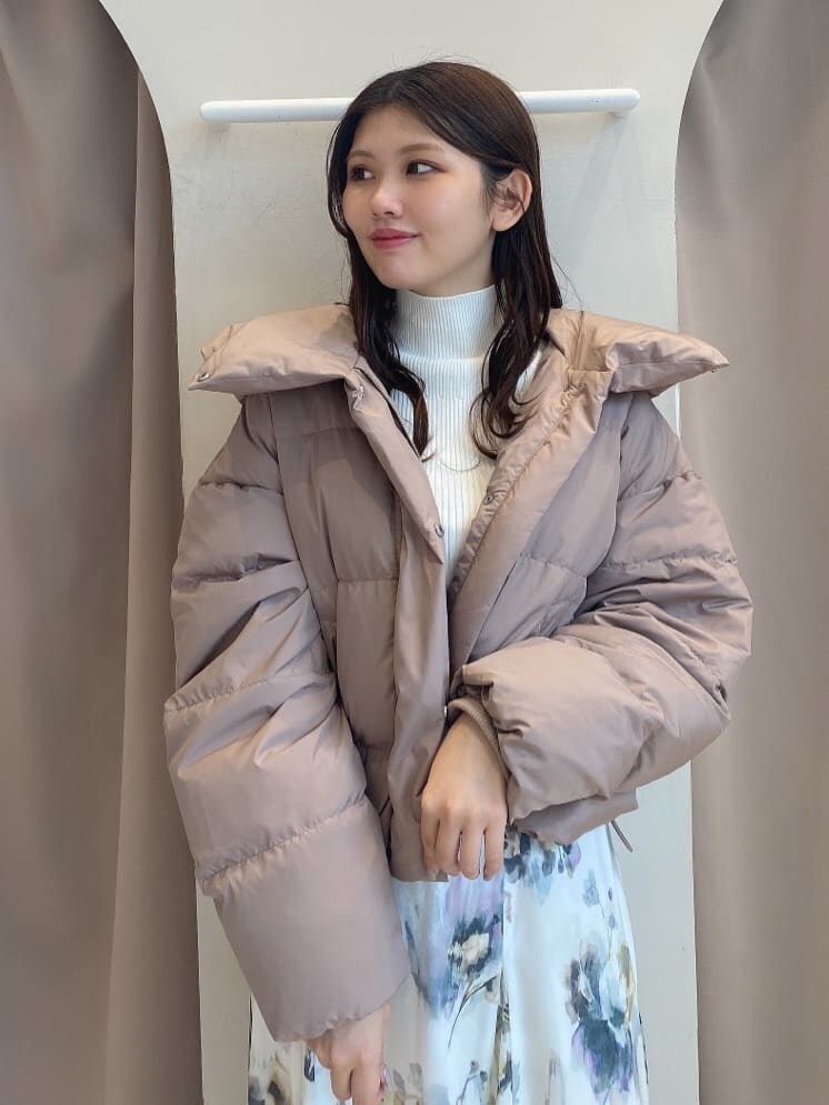 ホワイト系のスカート、ホワイト系のニット/セーター、ブラウン系のダウンジャケット/コートを着用したレディースの秋コーディネートの5枚目の写真