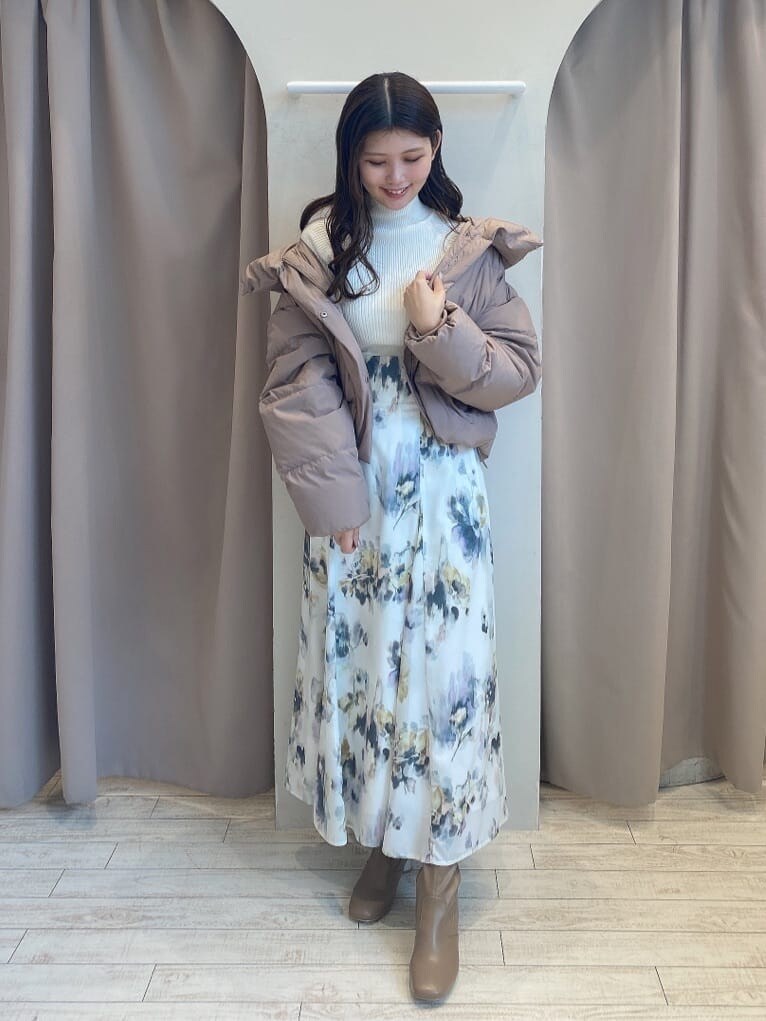 ホワイト系のスカート、ホワイト系のニット/セーター、ブラウン系のダウンジャケット/コートを着用したレディースの秋コーディネートの2枚目の写真