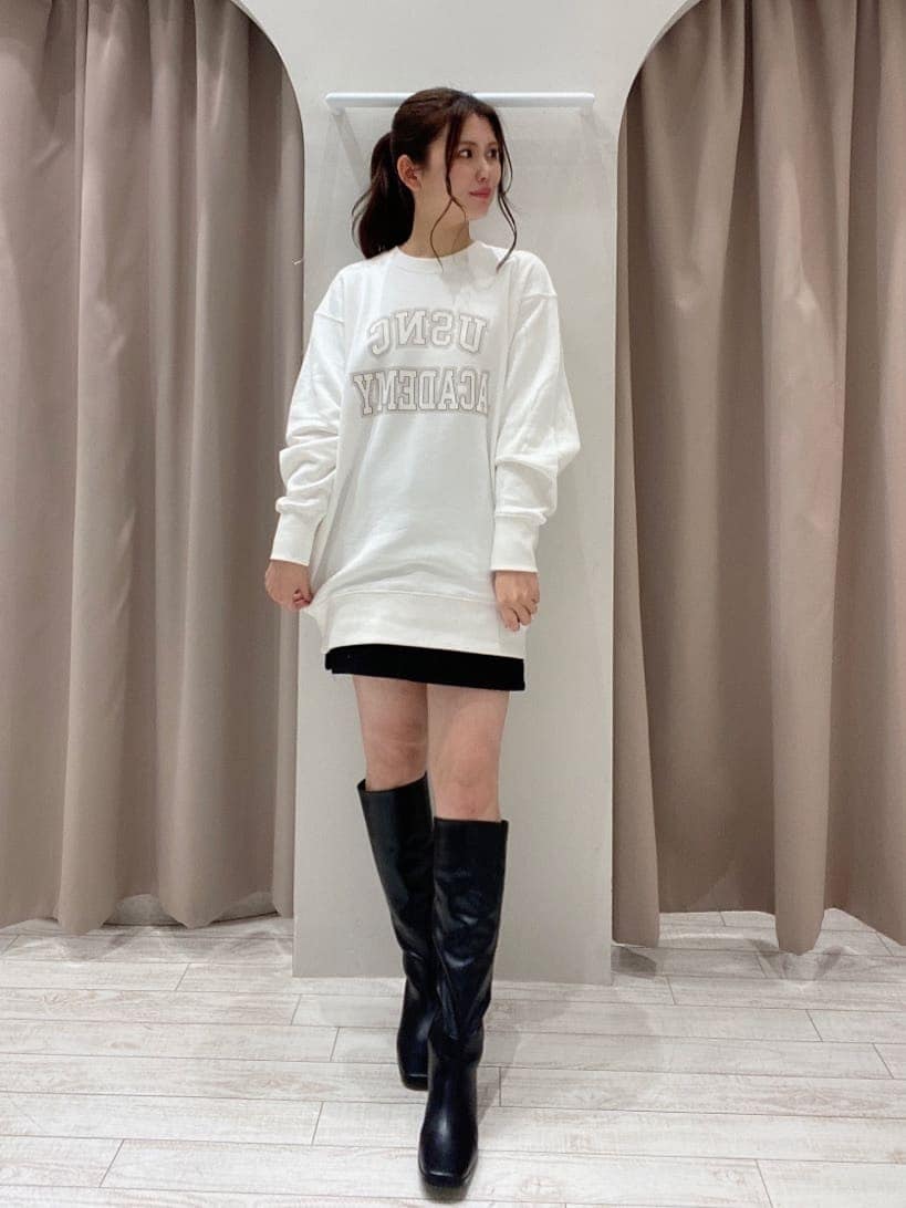 ホワイト系のスウェット、ブラック系のスカート、ブラック系のブーツを着用したレディースの冬コーディネートの2枚目の写真