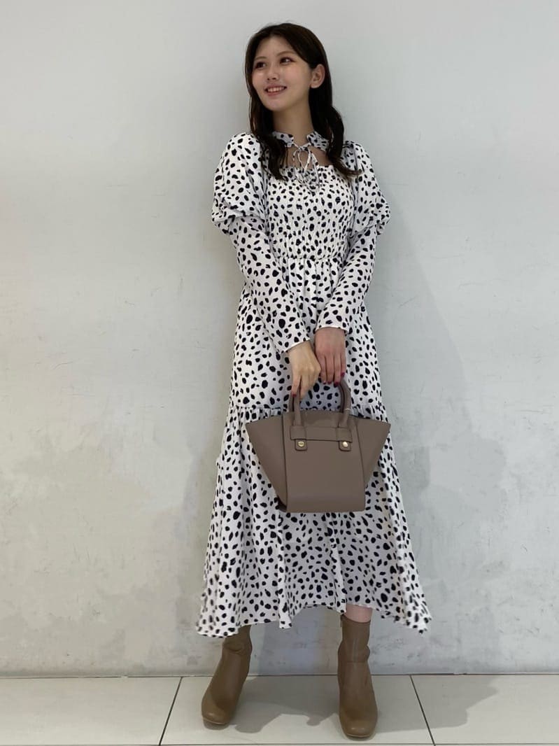 ベージュ系のブーツ、ブラウン系のハンドバッグ、ホワイト系のワンピースを着用したレディースの秋コーディネートの3枚目の写真