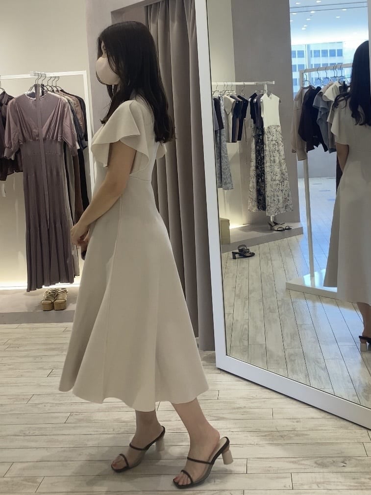 ホワイト系のワンピース、ベージュ系のトートバッグ、ブラウン系のサンダルを着用したレディースの夏コーディネートの3枚目の写真