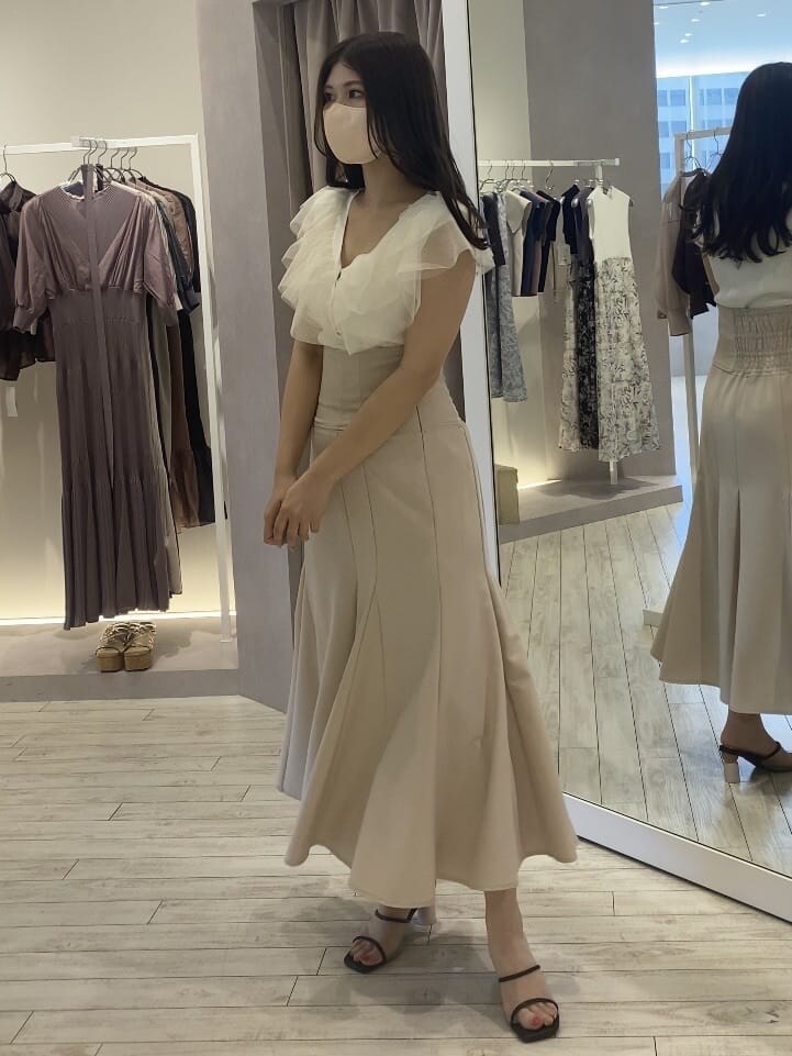 ピンク系のスカート、ブラウン系のサンダル、ホワイト系のカーディガン/ボレロを着用したレディースの夏コーディネートの3枚目の写真