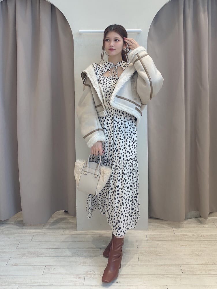 ブラウン系のブーツ、ベージュ系のムートンコート、ホワイト系のワンピースを着用したレディースの夏コーディネートの3枚目の写真