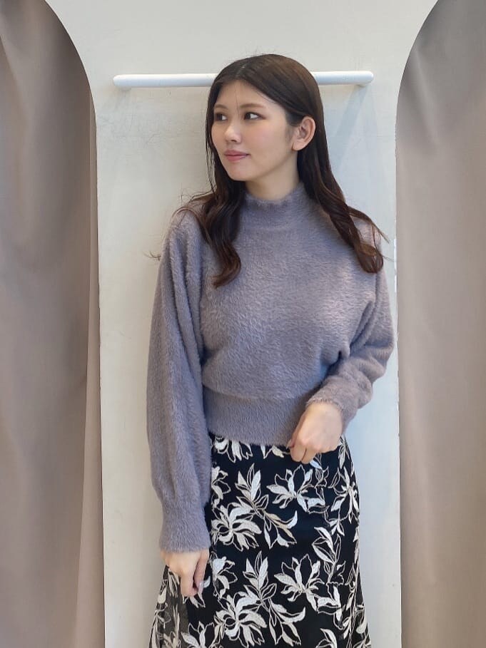 パープル系のニット/セーター、ブラック系のスカート、ブラック系のスカートを着用したレディースの秋コーディネートの4枚目の写真