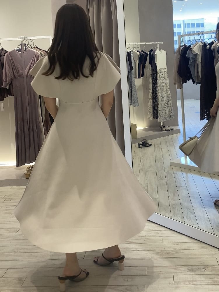 ホワイト系のワンピース、ベージュ系のトートバッグ、ブラウン系のサンダルを着用したレディースの夏コーディネートの4枚目の写真