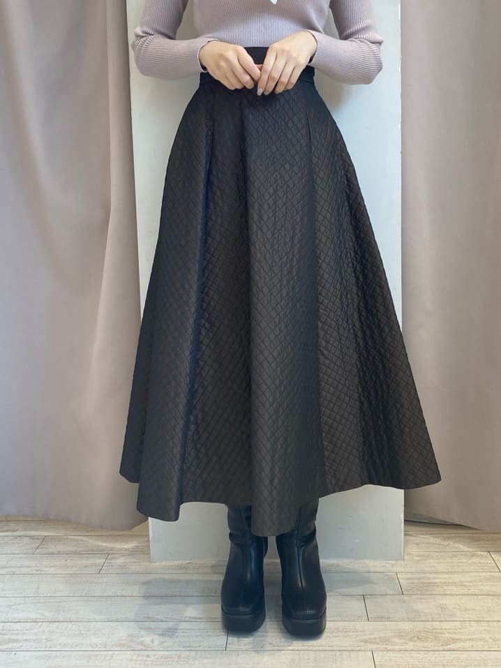 ブラウン系のスカート、ブラウン系のスカート、ブラック系のブーツを着用したレディースの秋コーディネートの6枚目の写真