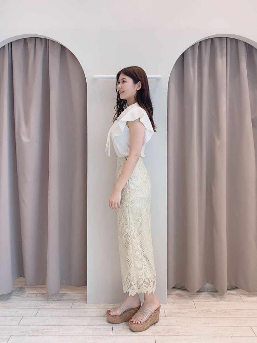 イエロー系のスカート、ホワイト系のニット/セーター、その他のサンダルを着用したレディースの春コーディネートの2枚目の写真