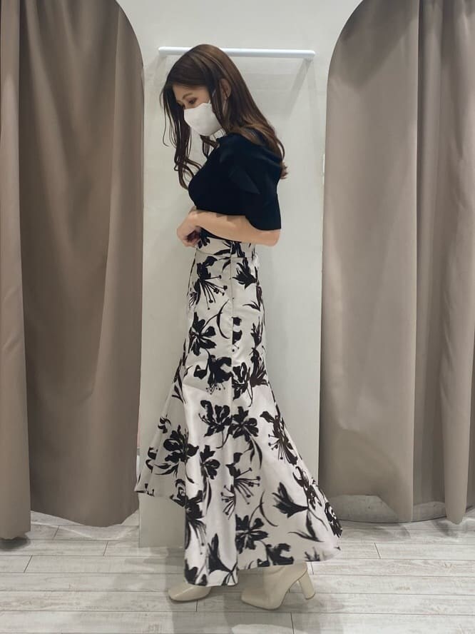 ホワイト系のスカート、ホワイト系のブーツ、ブラック系のニット/セーターを着用したレディースの夏コーディネートの3枚目の写真