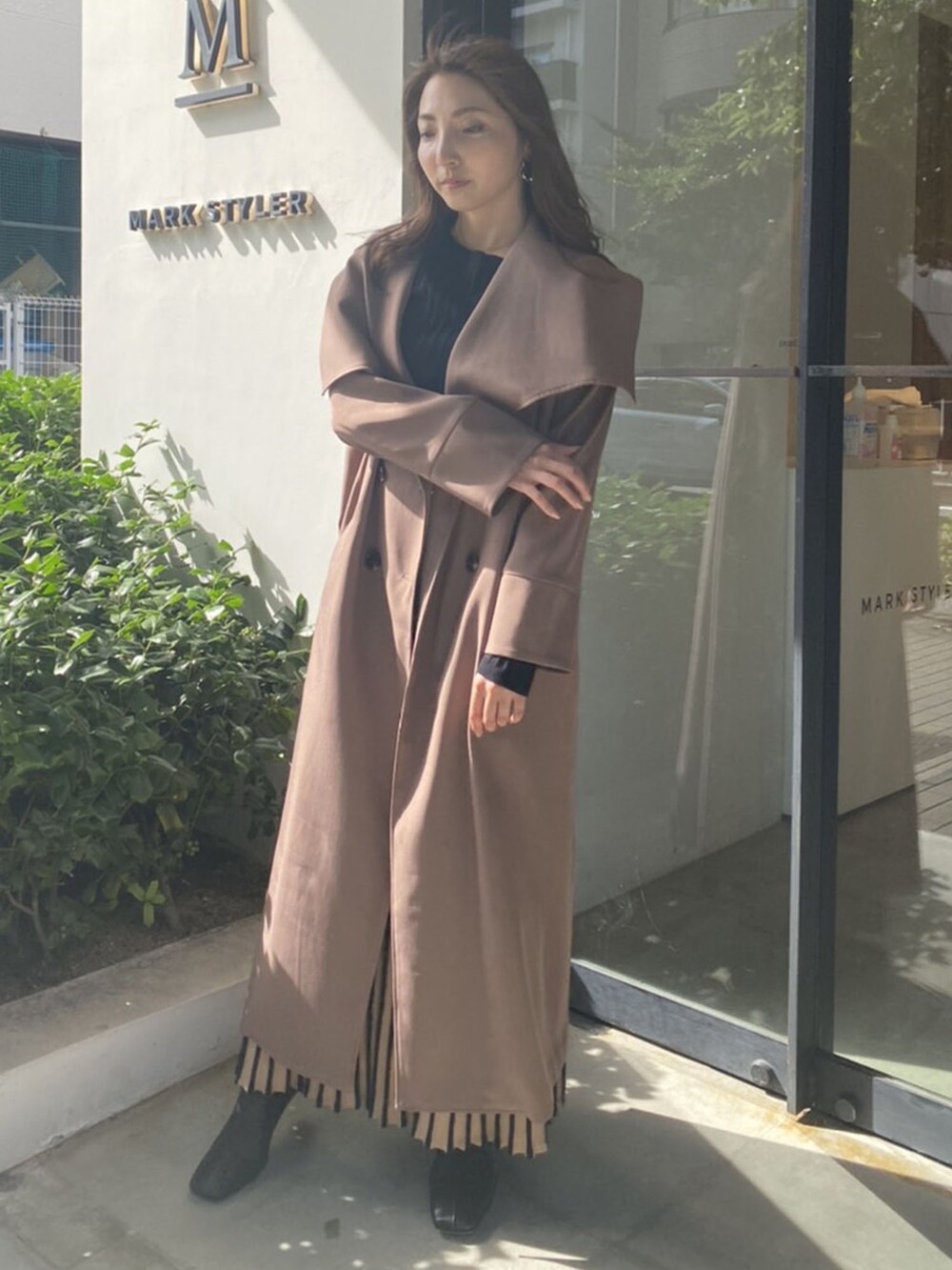 ブラック系のスカート、ベージュ系のその他アウター、ブラック系のニット/セーターを着用したレディースの秋コーディネートの3枚目の写真