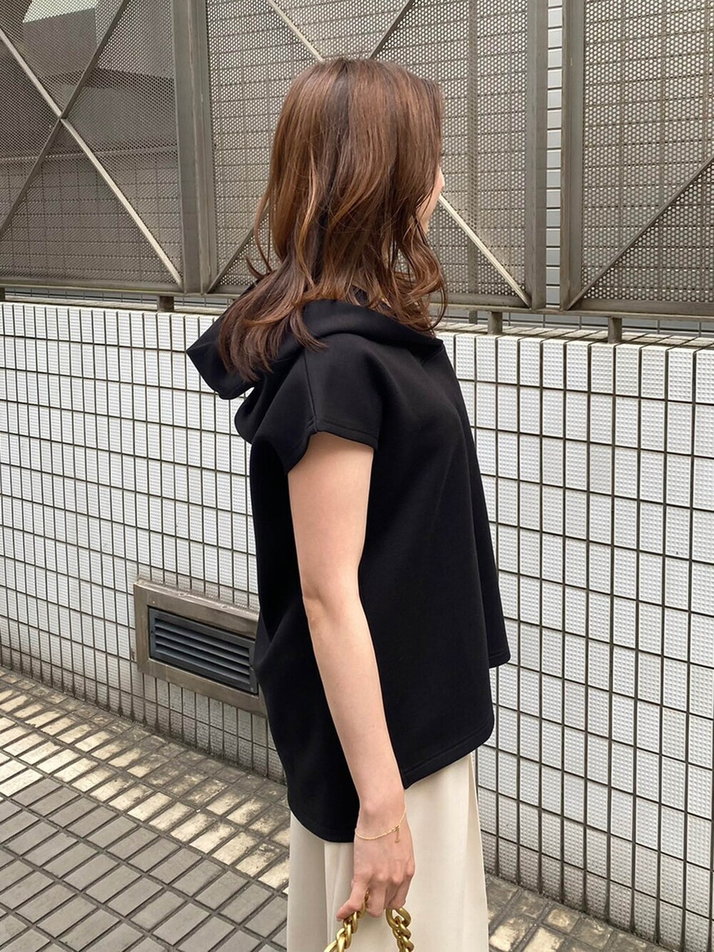 ブラック系のパーカー、ベージュ系のその他パンツを着用したレディースの春コーディネートの2枚目の写真