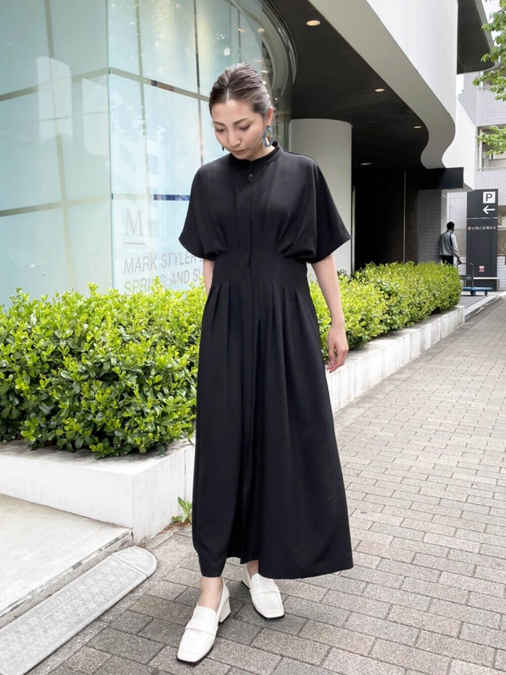 ブラック系のワンピースを着用したレディースの春コーディネートの2枚目の写真