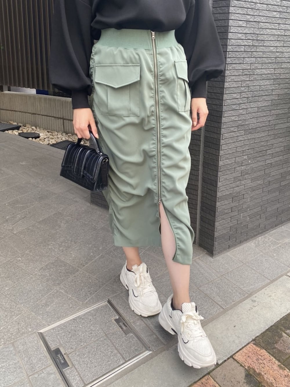 ブラック系のTシャツ/カットソー、ベージュ系のスカートを着用したレディースの秋コーディネートの3枚目の写真