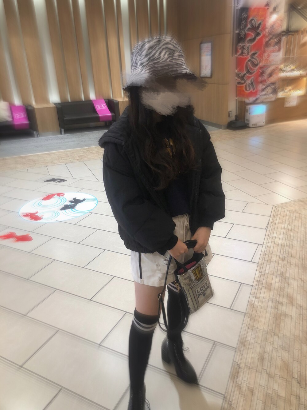 ブラック系のダウンジャケット/コート、ブルー系のトップス、シルバー系のバッグを着用したレディースの春コーディネートの2枚目の写真