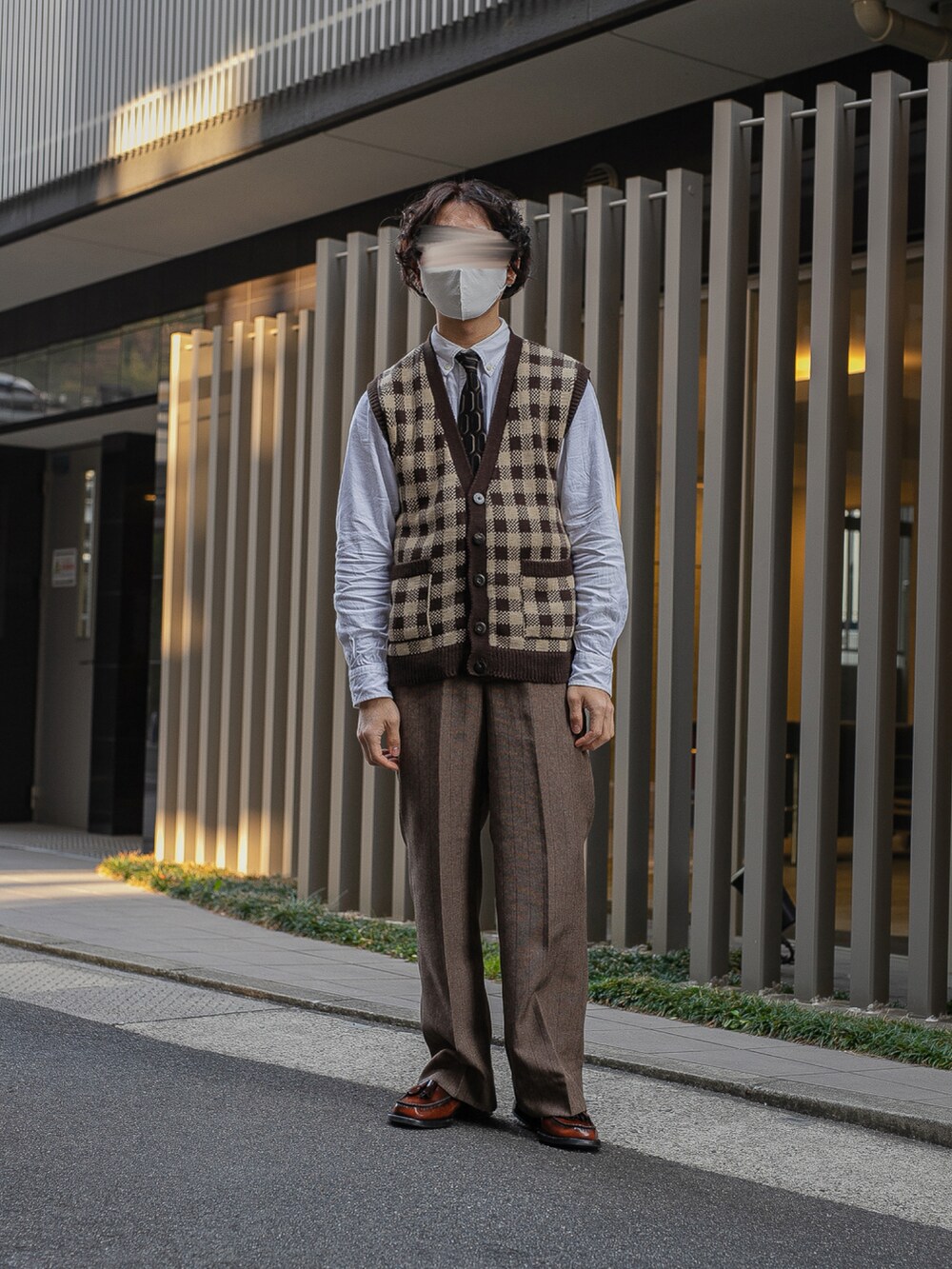 ベージュ系のニット/セーター、ブルー系のシャツ/ブラウス、ブラウン系のスラックスを着用したメンズの春コーディネートの2枚目の写真