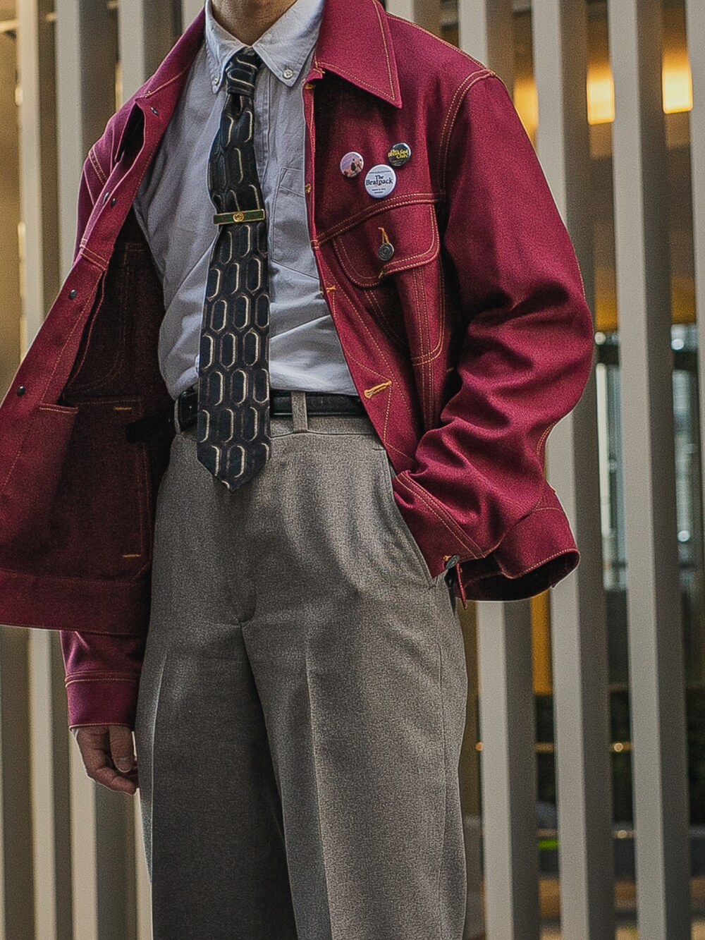 レッド系のデニムジャケット、ブルー系のシャツ/ブラウス、ベージュ系のスラックスを着用したメンズの春コーディネートの2枚目の写真