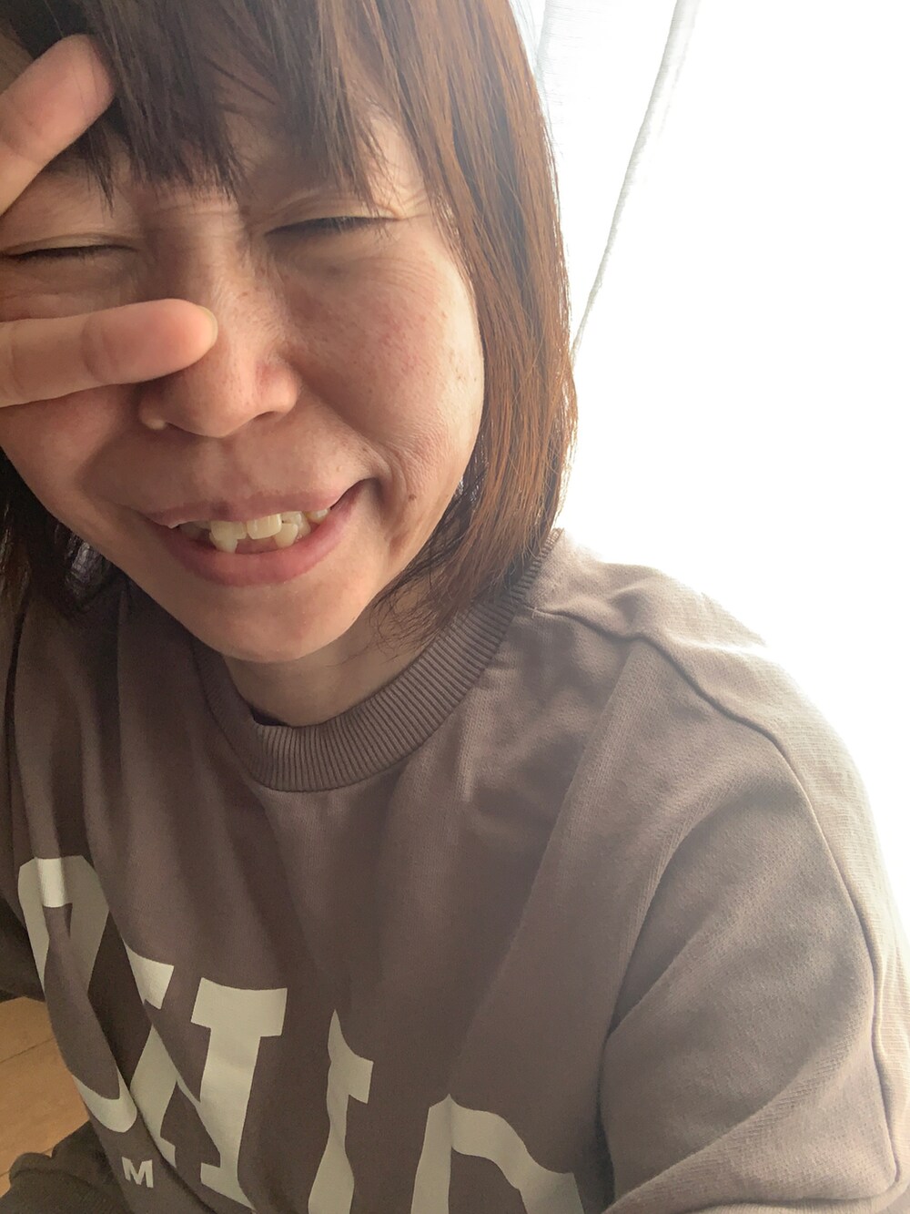 グレー系のトップス、ブルー系のデニムパンツを着用したレディースの冬コーディネートの2枚目の写真