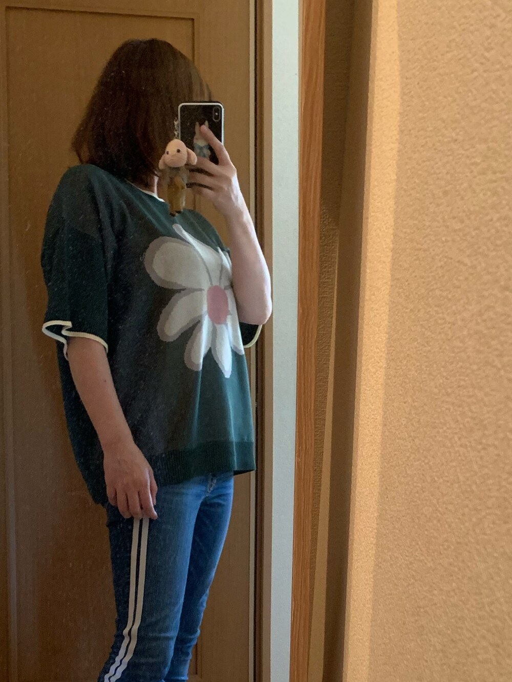 グリーン系のニット/セーター、ブルー系のデニムパンツを着用したレディースの夏コーディネートの2枚目の写真