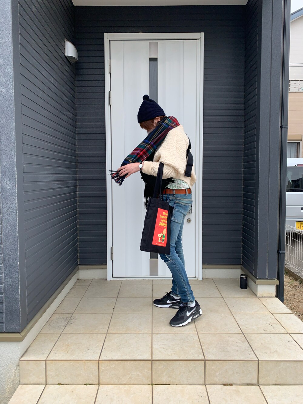 ブルー系のデニムパンツ、ブラック系のスニーカー、ブラック系のボディバッグ/ウエストポーチを着用したレディースの冬コーディネートの2枚目の写真