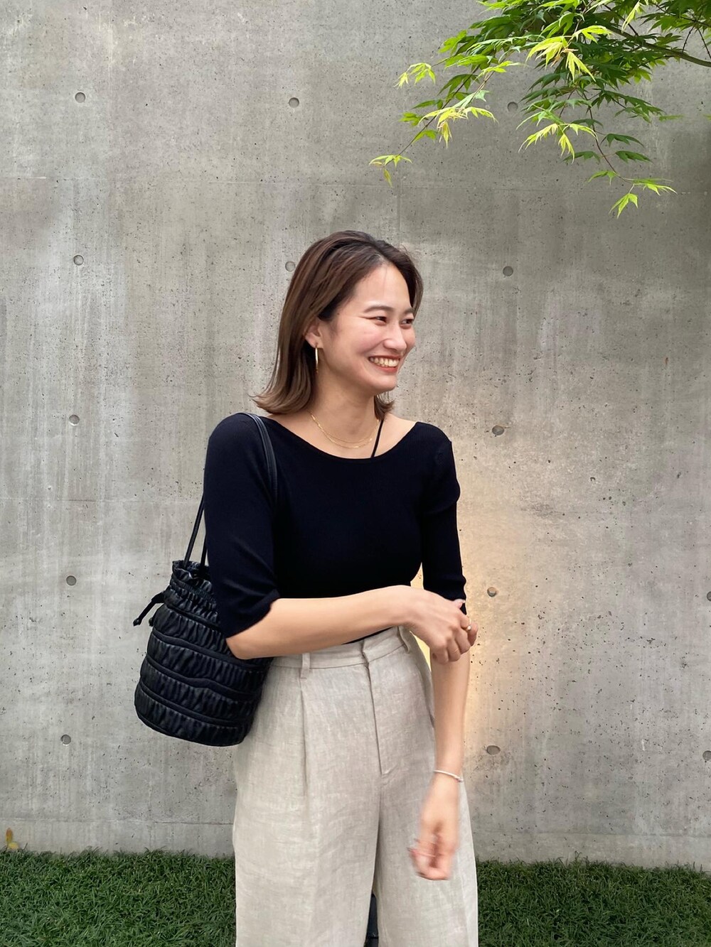 ブラック系のニット/セーター、ベージュ系のその他パンツを着用したレディースの春コーディネートの2枚目の写真