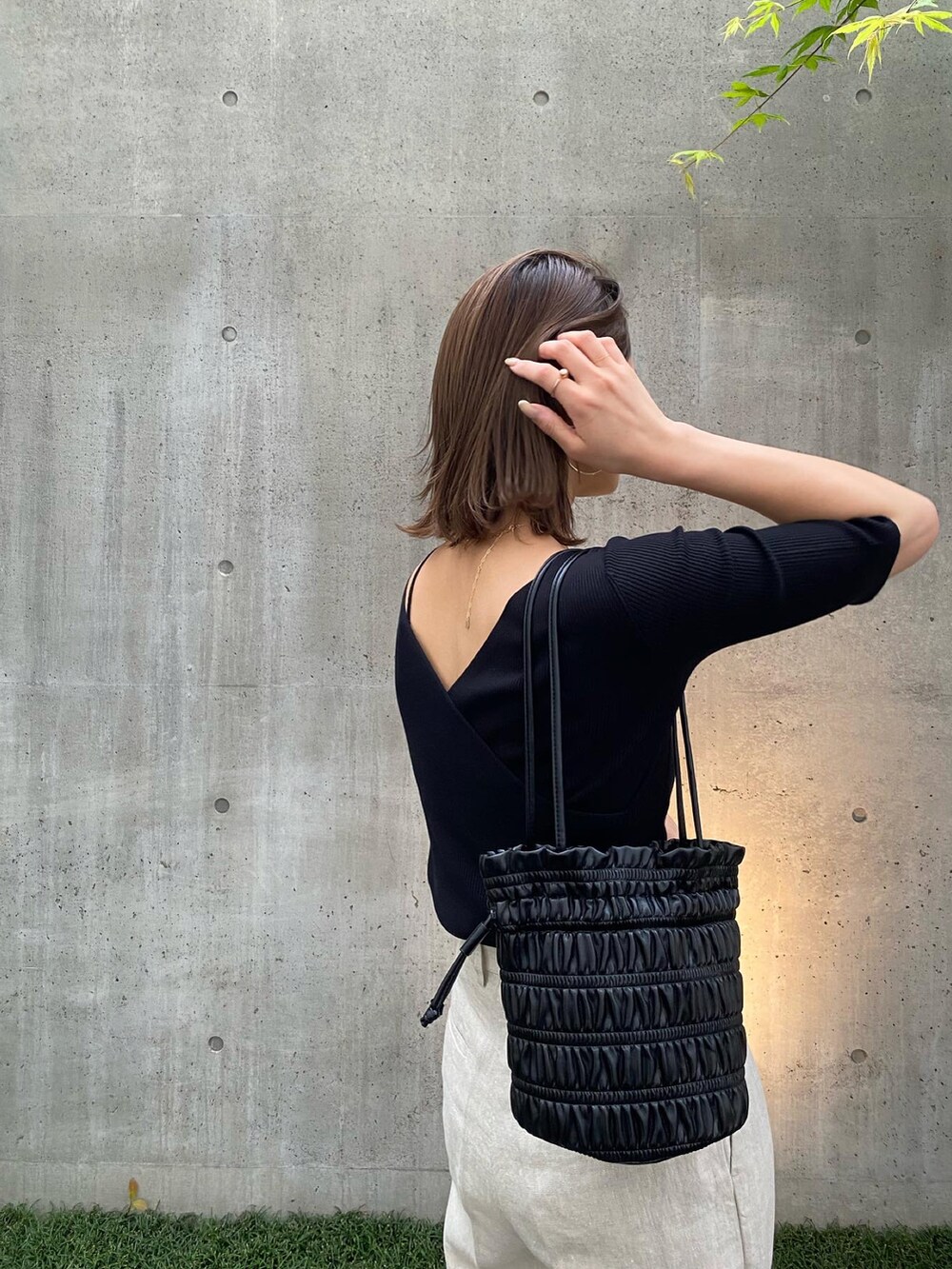 ブラック系のニット/セーター、ベージュ系のその他パンツを着用したレディースの春コーディネートの4枚目の写真