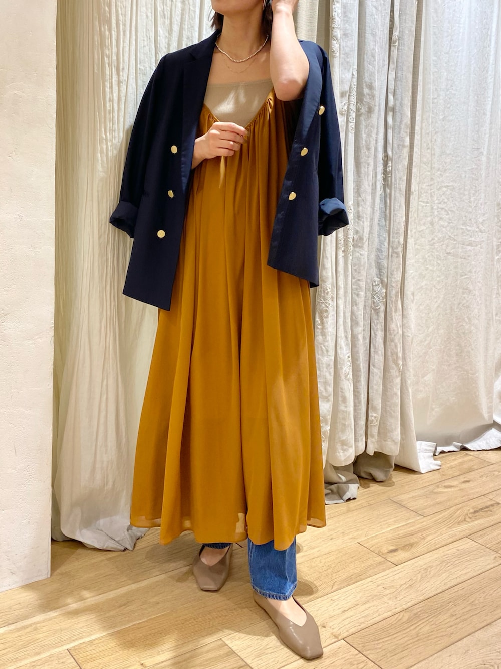 レッド系のワンピース、ブルー系のテーラードジャケットを着用したレディースの冬コーディネートの2枚目の写真