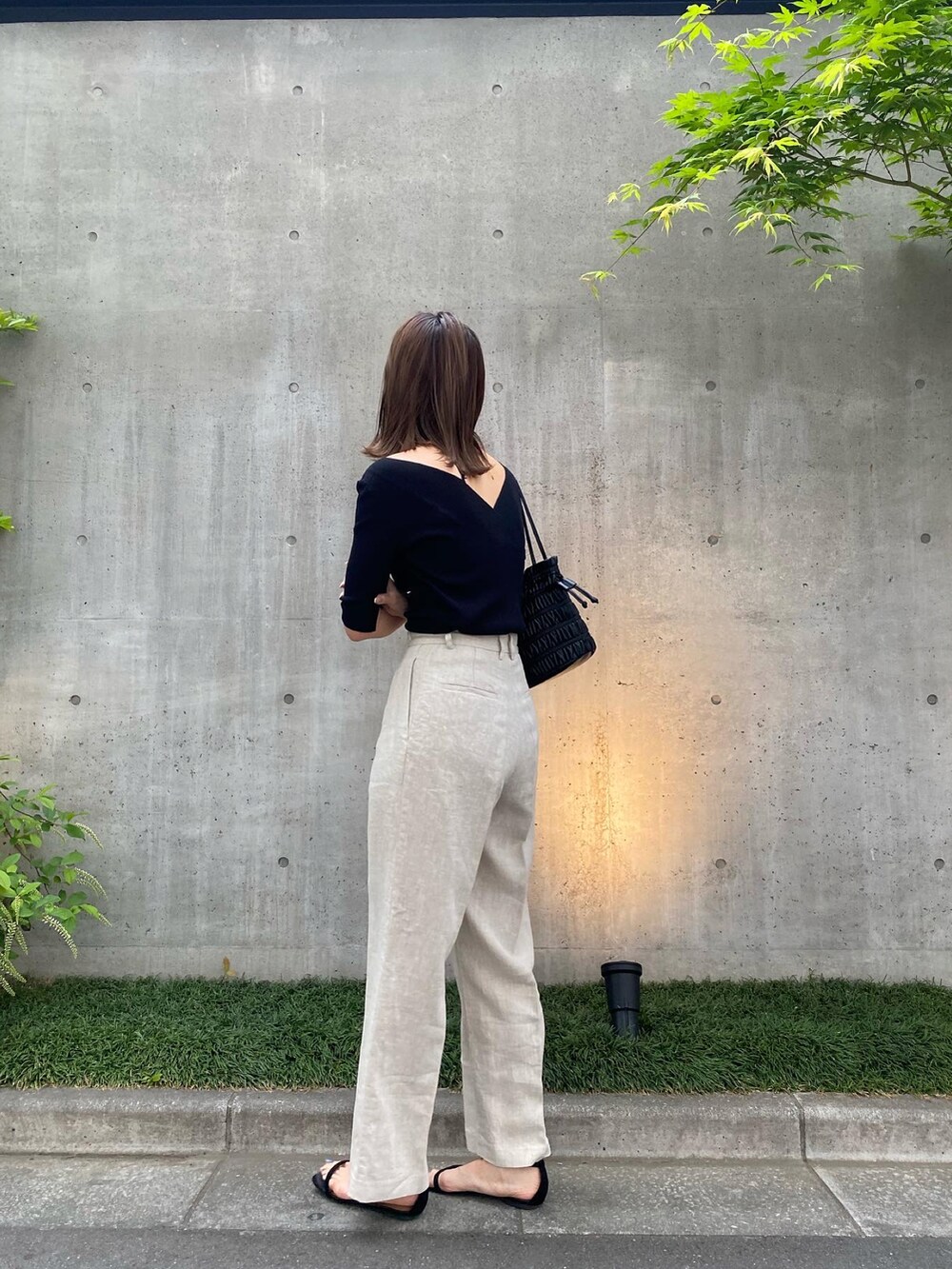 ブラック系のニット/セーター、ベージュ系のその他パンツを着用したレディースの春コーディネートの3枚目の写真