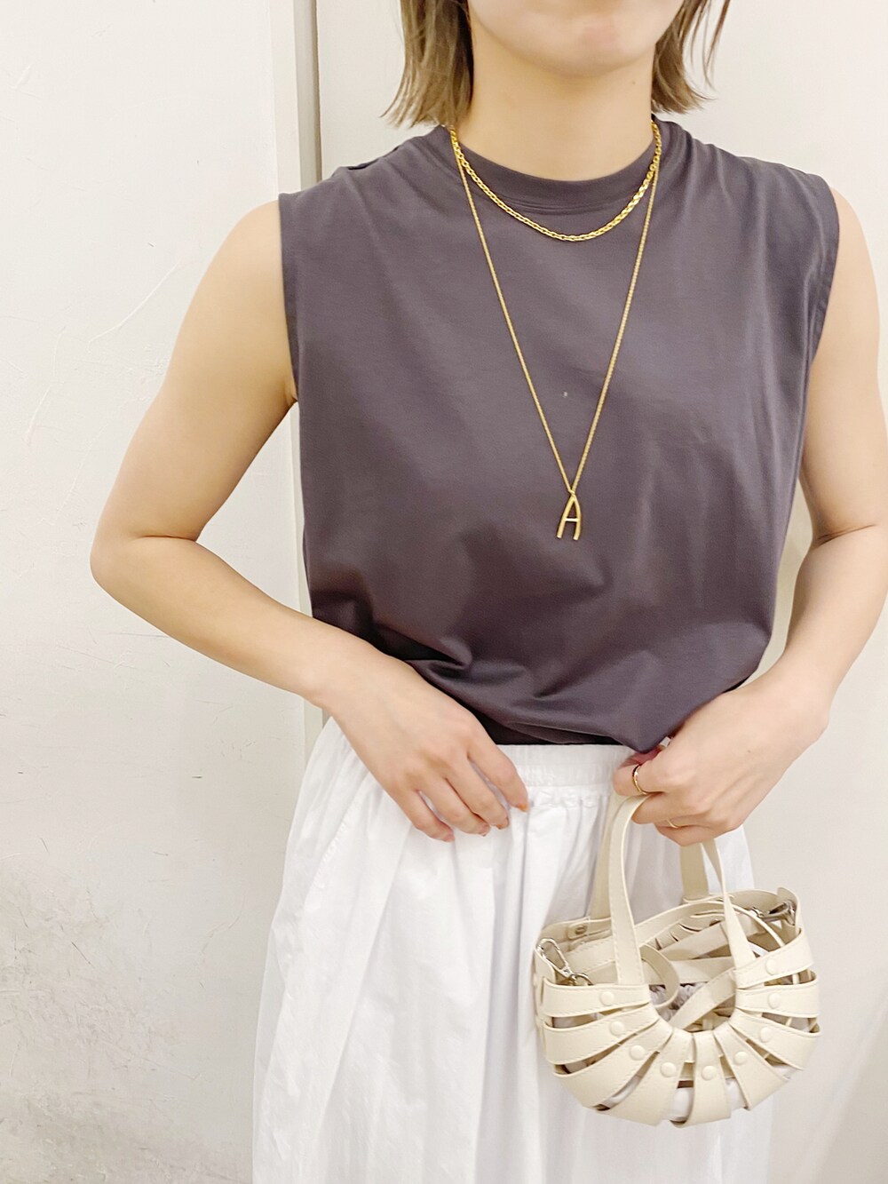 ホワイト系のTシャツ/カットソー、ホワイト系のスカート、ホワイト系のトートバッグを着用したレディースの夏コーディネートの2枚目の写真