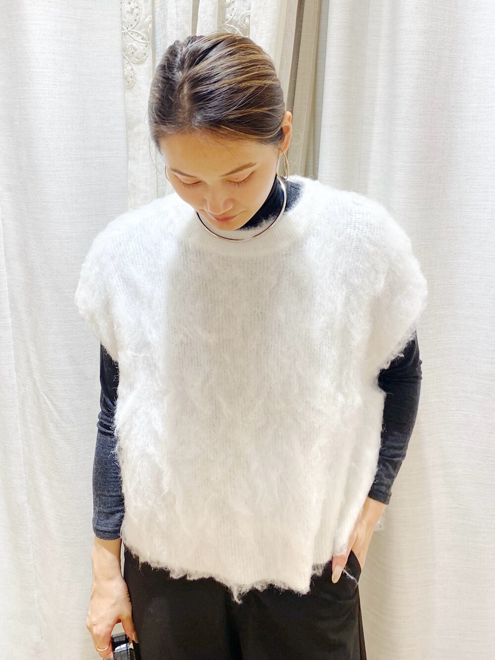 ホワイト系のベストを着用したレディースの冬コーディネートの2枚目の写真