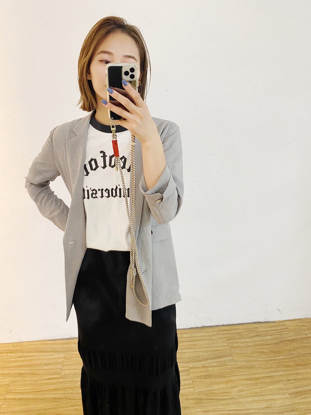 ホワイト系のTシャツ/カットソー、グレー系のテーラードジャケット、ブラック系のスカートを着用したレディースの冬コーディネートの2枚目の写真