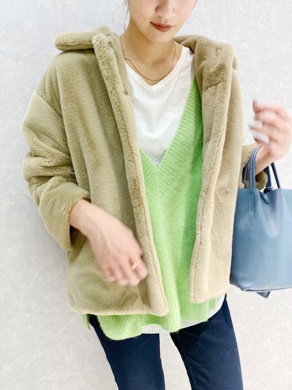 グリーン系のベスト、ベージュ系のその他アウター、ブラウン系のブーツを着用したレディースの秋コーディネートの2枚目の写真