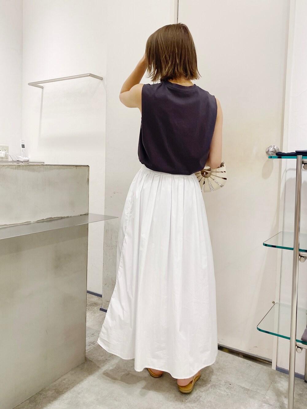 ホワイト系のTシャツ/カットソー、ホワイト系のスカート、ホワイト系のトートバッグを着用したレディースの夏コーディネートの3枚目の写真